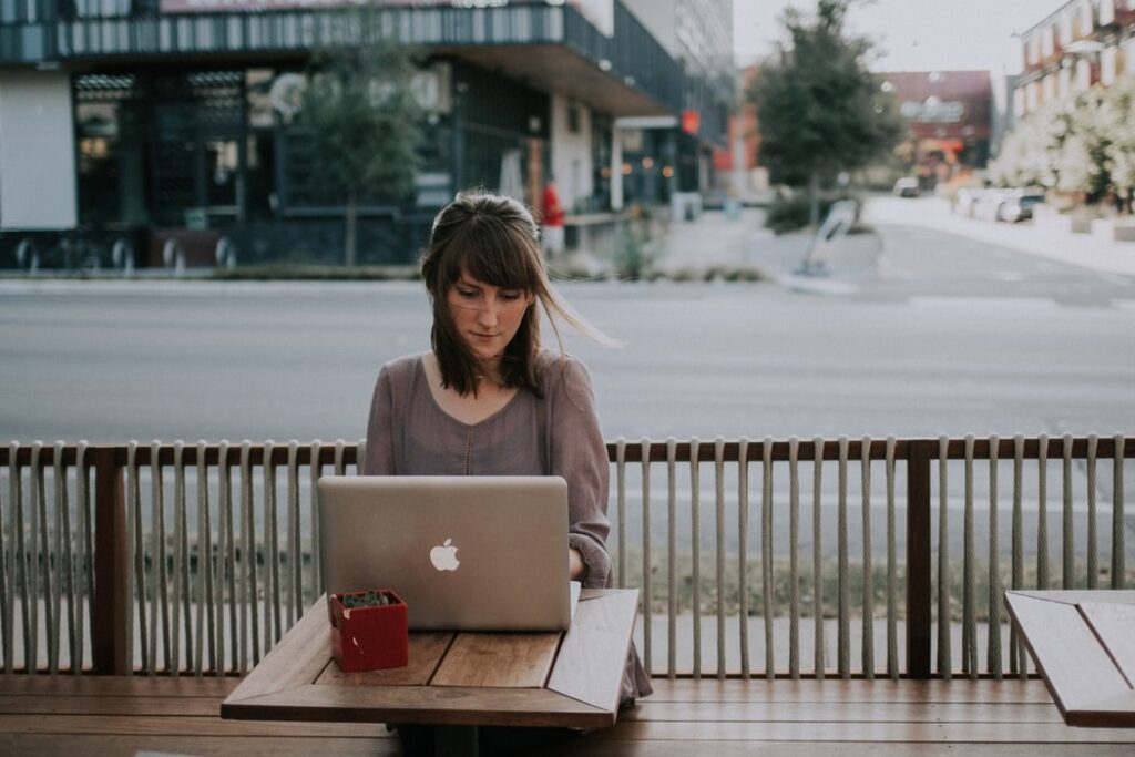 Distracted woman answers email on vacation and struggles with the value of paid time off